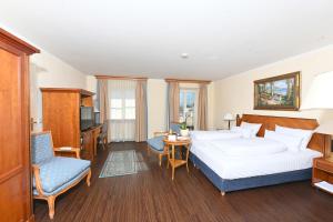 ein Hotelzimmer mit 2 Betten und einem Stuhl in der Unterkunft Residenz Heinz Winkler in Aschau im Chiemgau