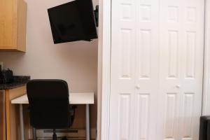 a door with a television and a desk and a chair at Charming Studio in Boston Brownstone, C.Ave#5 in Boston