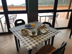 a table with breakfast food and orange juice on it at Hotel Parrilla el Zangano in Boal