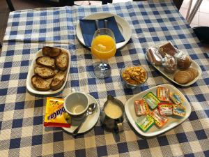 a table topped with plates of breakfast food and orange juice at Hotel Parrilla el Zangano in Boal