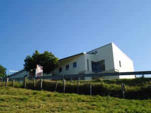 a white building on top of a grassy hill at Hotel Parrilla el Zangano in Boal