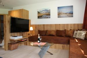 sala de estar con sofá marrón y TV de pantalla plana en Traum-Ferienwohnungen Wechselberger Schwendau en Schwendau