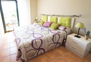 ランポーヤにあるLavandaのベッドルーム1室(ピンクと緑の枕が付いたベッド1台付)