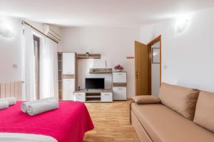 a living room with a couch and a television at Apartments Prekalj in Poreč