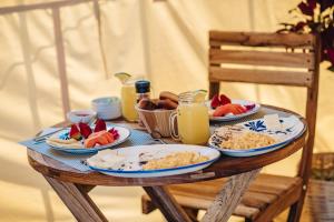 a wooden table with plates of food on it at Entre Rios Glamping in Calarcá