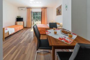 a room with a dining table and a bedroom at Apartments Prekalj in Poreč