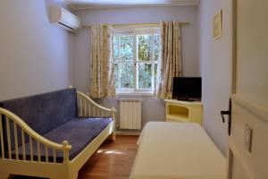 a small room with a blue couch and a window at Pousada Jardim Azul in Canela