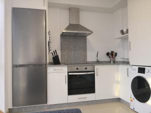 a kitchen with white cabinets and a stainless steel appliance at Apartamento en Ribeira(centro) 1*planta in Ribeira