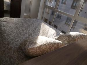 a bed with a comforter and pillows next to a window at Apartamento en Ribeira(centro) 1*planta in Ribeira