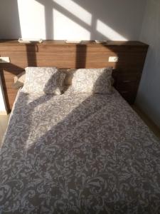 a bedroom with a bed with a wooden headboard at Apartamento en Ribeira(centro) 1*planta in Ribeira