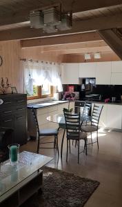 a kitchen with a table and chairs and a counter at Domek na Cichej Leśniewo in Leśniewo