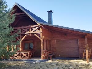 a log cabin with a garage in front of it at Domek na Cichej Leśniewo in Leśniewo