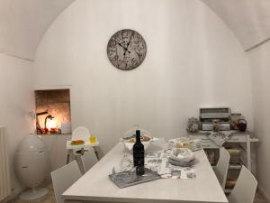 a dining room with a table and a clock on the wall at MaGiA in Lecce