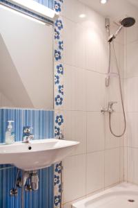 a bathroom with a sink and a shower with a mirror at Arno Apartments in Kuressaare