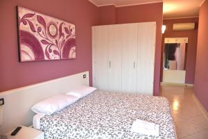 1 dormitorio con 1 cama y una pintura en la pared en Agriturismo Argaland, en Parma