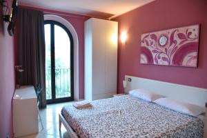 1 dormitorio con cama y pared de color rosa en Agriturismo Argaland, en Parma