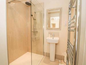 een badkamer met een glazen douche en een wastafel bij Brooksides Byre Durham Country Cottage in Durham
