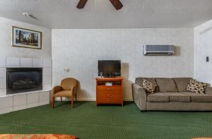 a living room with a couch and a tv and a fireplace at Miners Inn in Mariposa