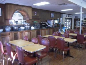 un restaurant avec des tables, des chaises et un comptoir dans l'établissement Miners Inn, à Mariposa