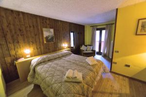 a bedroom with a bed with two towels on it at Hotel Gran Baita in Folgarida