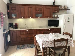 cocina con mesa y nevera blanca en Casa Sirena, Locazione Turistica, en Polignano a Mare