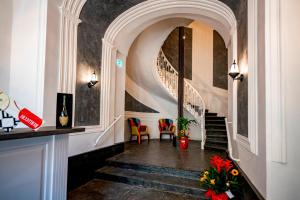 ナポリにあるVilla Elisio Hotel & Spaの椅子と花の階段のある廊下