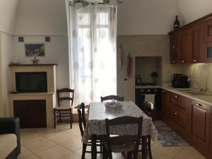 una cucina con tavolo, sedie e finestra di Casa Sirena, Locazione Turistica a Polignano a Mare