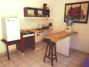 a small kitchen with a counter and a refrigerator at Casa Lao Centro in Zihuatanejo