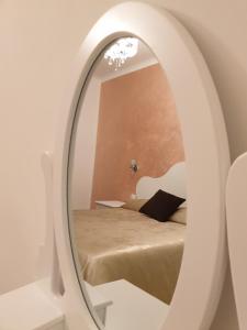 um quarto com uma cama e um espelho em Museum Guest House em Civitavecchia