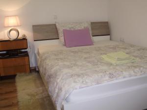ein Schlafzimmer mit einem großen Bett und einem lila Kissen in der Unterkunft Apartment Maximilian-free parking!!! in Zagreb