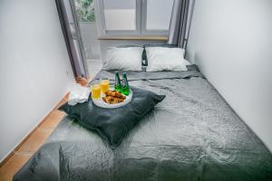 a bed with a plate of food and drinks on it at Apartament w Centrum in Ustka