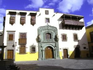 un grande edificio bianco con una porta e un balcone di Apartamentos Catalina Park a Las Palmas de Gran Canaria