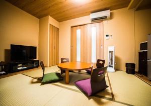 Kyoto - House / Vacation STAY 3816 في كيوتو: غرفة معيشة مع طاولة وكراسي خشبية