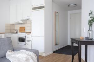 Una cocina con un refrigerador blanco y una mesa. en Torget Apartment Länsiportti, en Pori