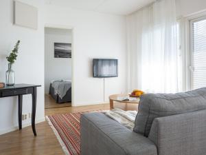 una sala de estar con un sofá y una mesa en Torget Apartment Länsiportti, en Pori