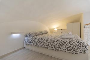 Schlafzimmer mit einem Bett mit einer schwarzen und weißen Bettdecke in der Unterkunft Domy House in Caserta