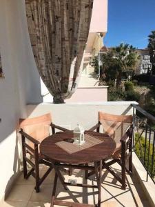 - Balcón con mesa de madera y 2 sillas en Harmony Apartment, en Kallithea Halkidikis