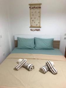a bed with two towels on top of it at Harmony Apartment in Kallithea Halkidikis