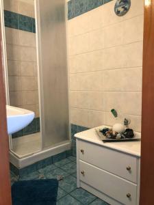 a bathroom with a shower and a sink and a dresser at Harmony Apartment in Kallithea Halkidikis