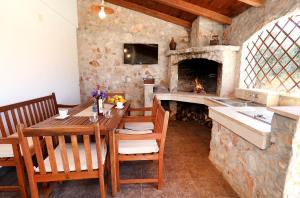 una sala da pranzo con tavolo e camino di Vila SanAdrija a Mali Drvenik (Zirona Piccola)