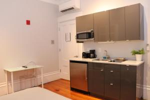 a kitchen with a sink and a microwave at Downtown Beacon Hill, Convenient, Comfy Studio #1 in Boston