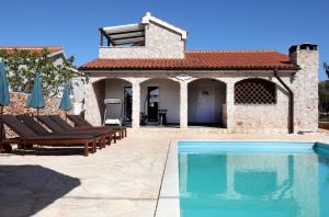 a villa with a swimming pool in front of a house at Vila SanAdrija in Drvenik Mali