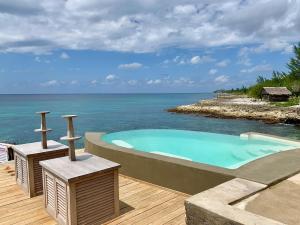 una piscina en una terraza junto al océano en The Westender Inn, en Negril