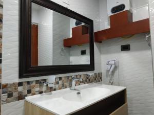 La salle de bains est pourvue d'un lavabo et d'un miroir. dans l'établissement APARTAMENTOS DECOR, à Carthagène des Indes