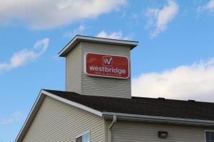 una señal en la parte superior de un edificio en Westbridge Inn & Suites, en Carrollton