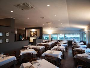 a dining room with tables with white tablecloths at Miramaretellaro in Tellaro