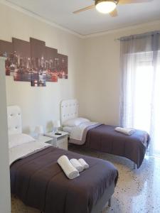 a bedroom with two beds and a window at Casagioiosa18 in Palermo