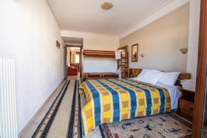 una camera con un letto con una coperta gialla e blu di Holiday Zigos a Igoumenítsa Altre 37 foto