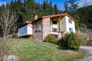 une image d'une maison sur une colline dans l'établissement La Riega del Peral, à Ojedo