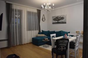 een woonkamer met een blauwe bank en een tafel bij Zlatibor M in Zlatibor